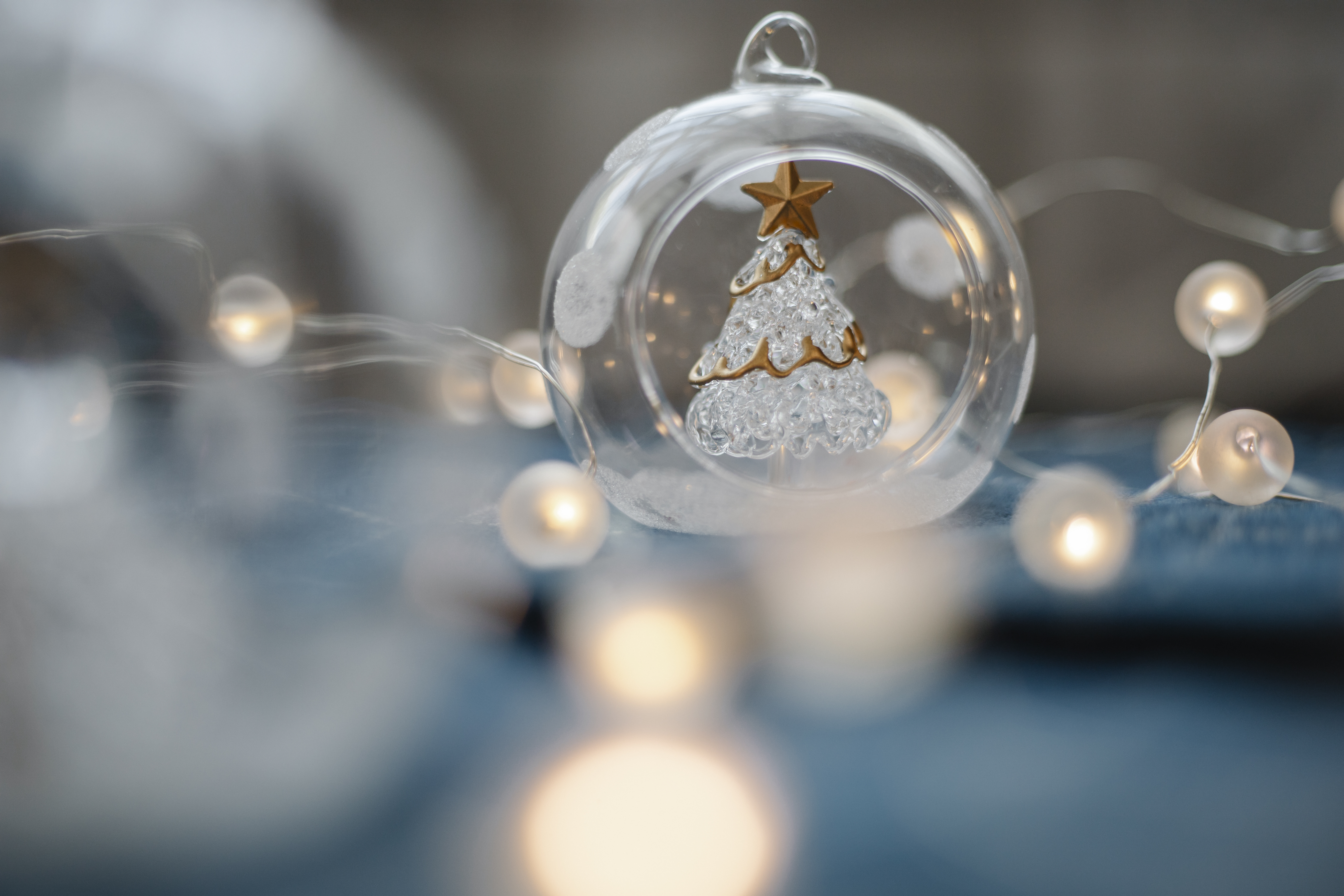 Free Glass Christmas tree inside transparent ball surrounded by burning garland for festive decorations Stock Photo
